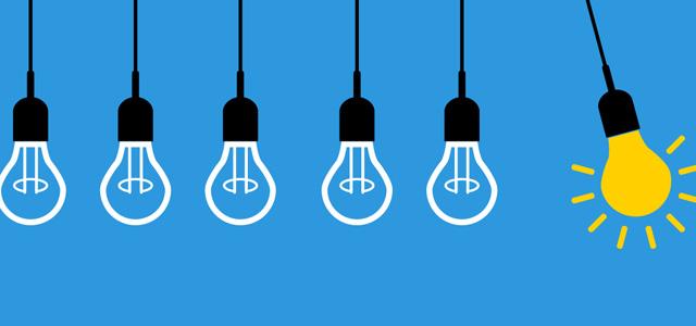 A row of hanging light bulbs, with one glowing yellow bulb standing out among the unlit bulbs against a blue background.